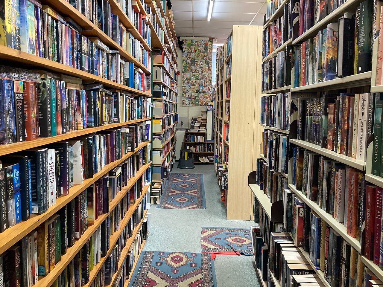 A narrow aisle between tall book shelves